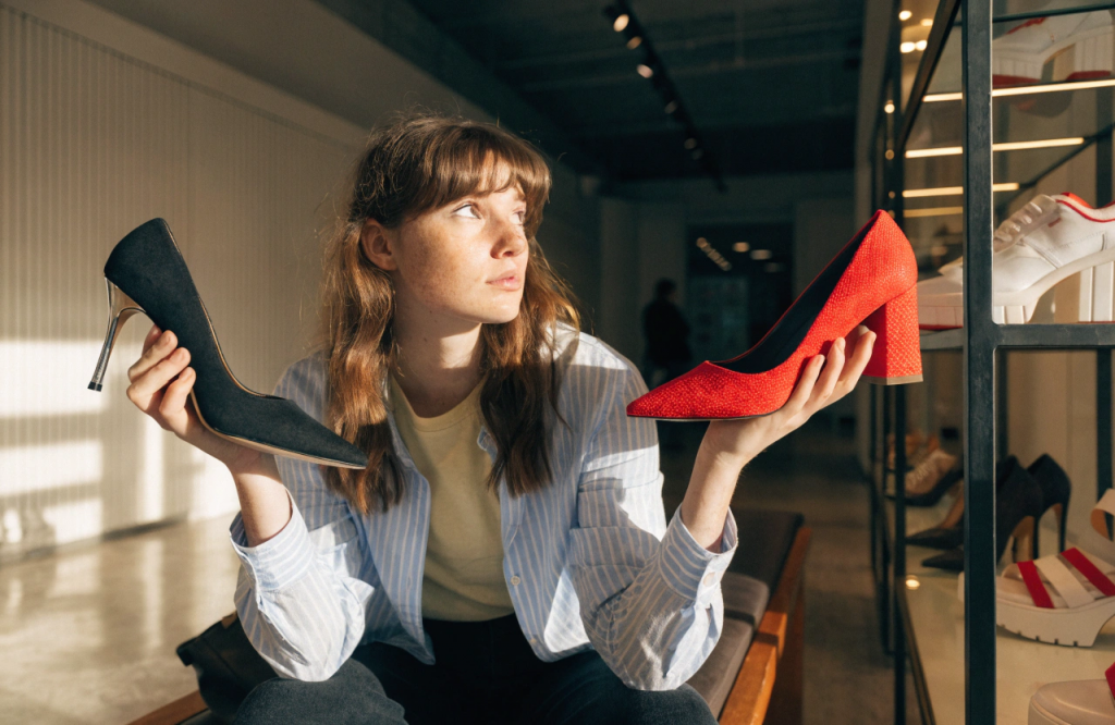 the-woman-is-holding-one-shoe-in-one-hand-and-anot.png