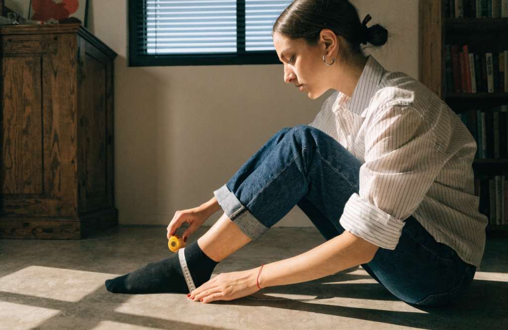 a-woman-measures-her-foot-with-a-tape.png